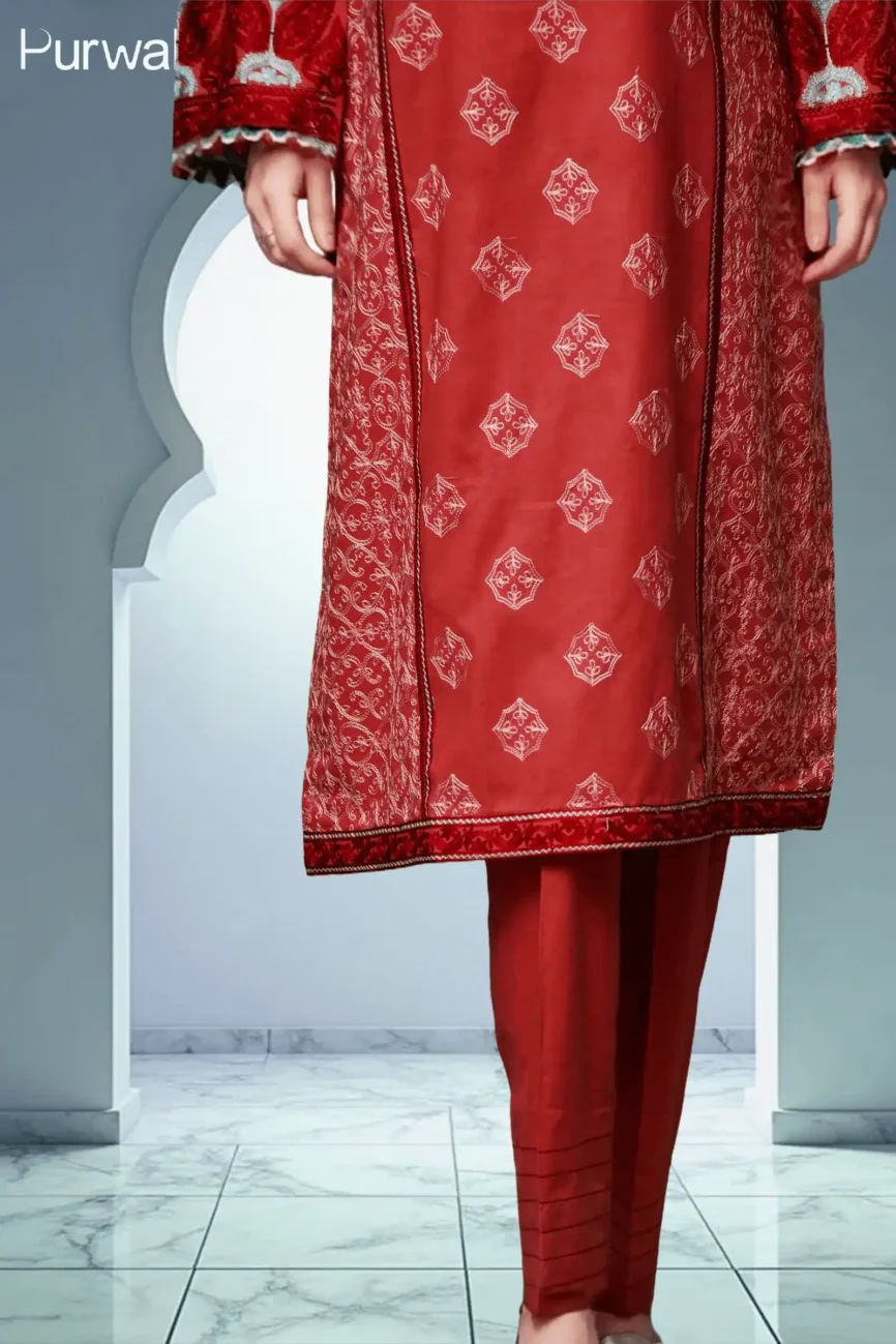 A close-up view of a red traditional dress with intricate embroidery and matching red pants