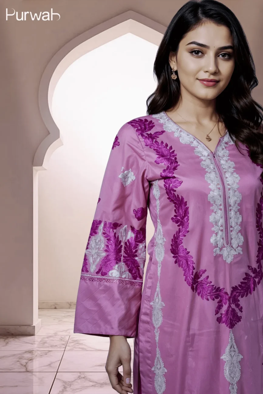 Close-up of a model in a purple embroidered dress featuring silver floral detailing, with a V-neck and subtle jewelry, posed in front of a traditional arch.