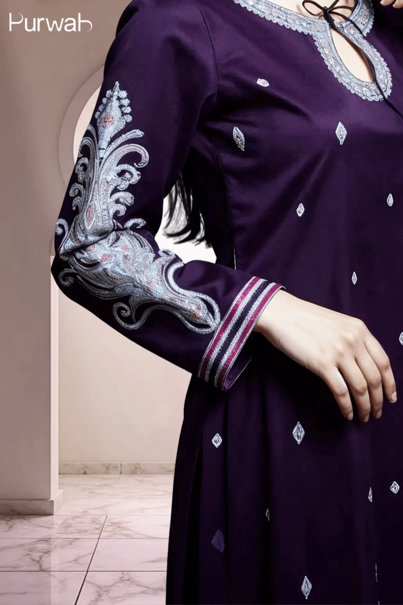 Detailed view of a purple dress with elaborate silver embroidery on the sleeves and neckline.